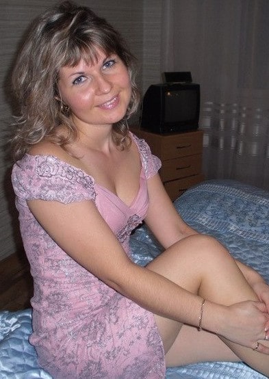 Pevačica pozira u uskoj roze haljini na krevetu