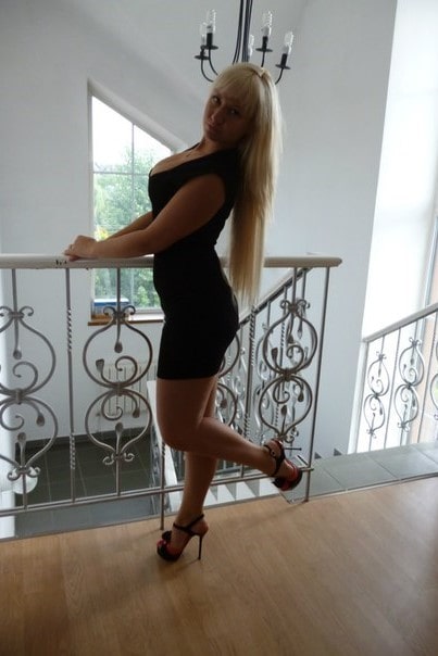 Bogatašica, zgodna plavuša duge kose pozira provokativno u seksi crnoj haljini u hotelu